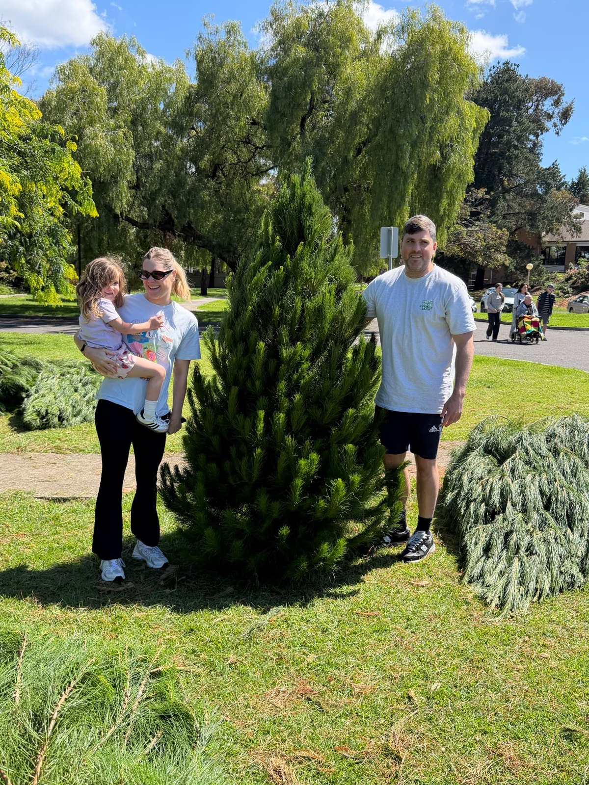 A family choosing a fresh real Christmas tree at Mina's Northcote tree lot